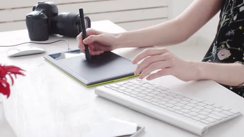 Woman Using Graphics Tablet and Typing on Keyboard