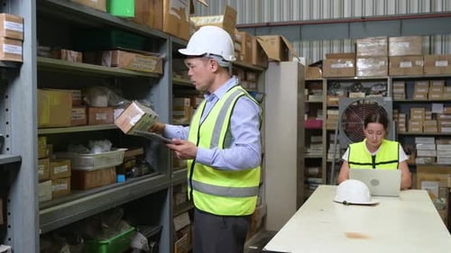 Responsable d'entrepôt et employée d'entrepôt comptant les petites pièces stockées
