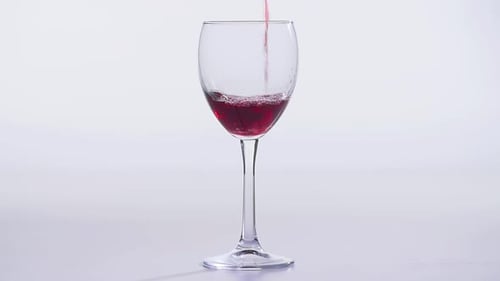 Red Liquid Pouring Into a Clear Wine Glass