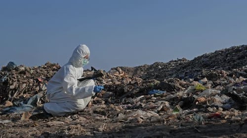 Scientist Studying Trash Pile in Protective Suit
