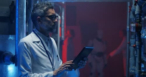 Scientist Checking Equipment and Using Tablet