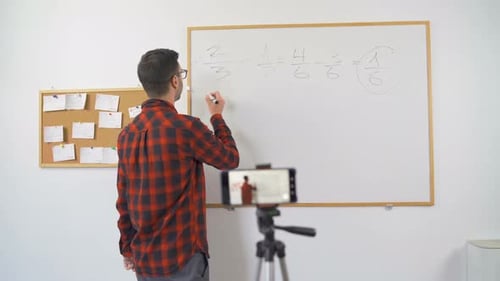 Male Math Teacher Lecturing To Camera at Whiteboard