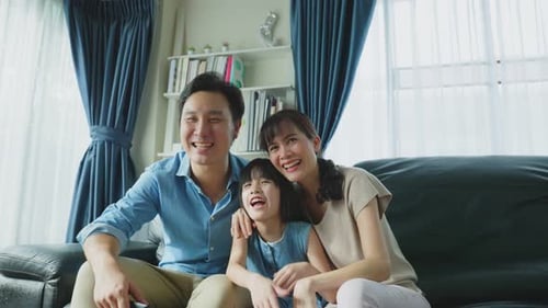 Happy Family Laughing on Sofa, Watching TV