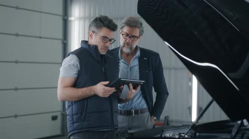 Mechanic Checking Car Diagnostics in a Tablet