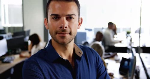 Male executive standing with arms crossed in office 4k
