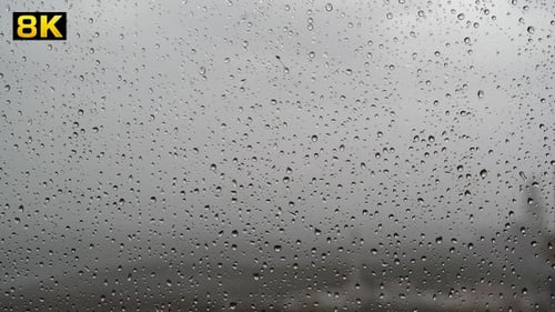 Raindrops Streaking Down Window Glass During Storm