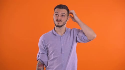 Man Scratching Head in Confusion on Orange Background