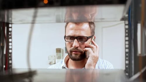 Technician talking on phone in server room