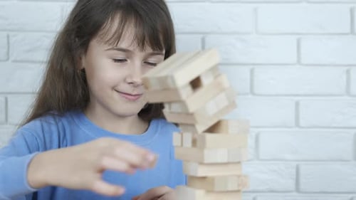 Das Kind spielt die Jenga.