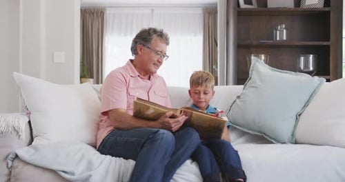 Grandfather and Grandson Looking at Photo Album Together