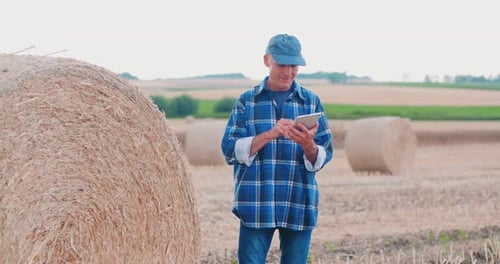 Farmer Using Digital Tablet While Examining Field