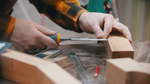 Woodworker Carefully Chiseling Wood With Hand Tools