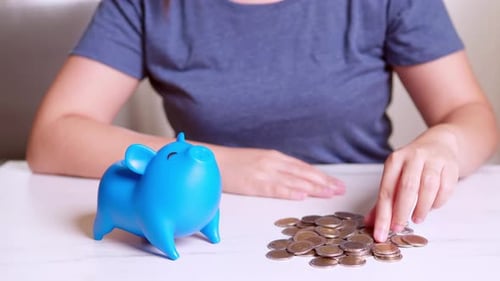 Woman putting coin in piggy bank, saving money concept. Future needs loan education or mortgage cred