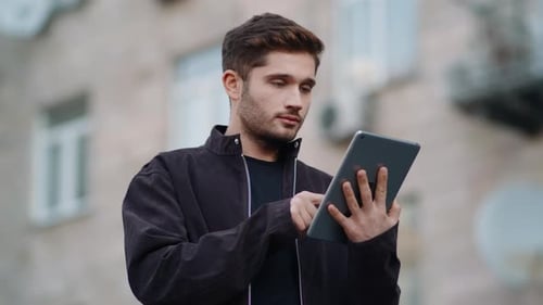 Smiling Guy Reading Message Tablet Outdoors, Happy Man Using Tablet on Street