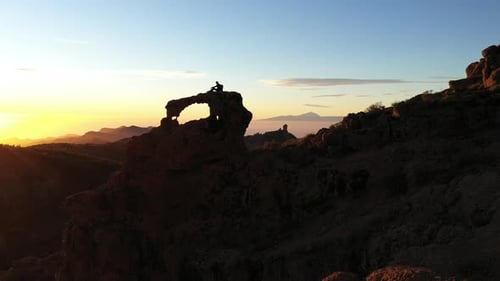 Man Standing In Mountain Landscape At Sunset