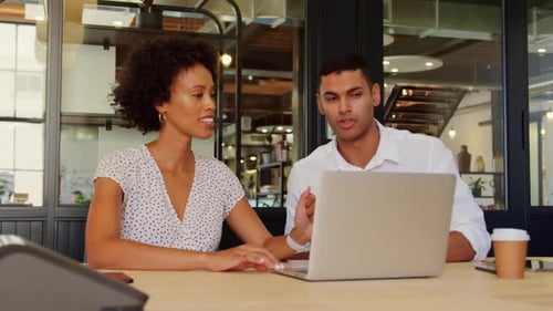 Business people discussing over laptop in modern office 4k