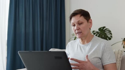 Woman Talking on Laptop at Home