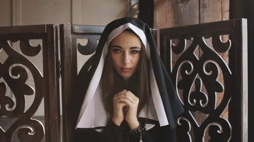 Young Woman in Nun Habit with Hands Clasped