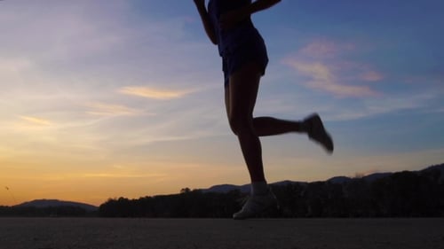 Silhouetted Woman Jogging During Colorful Sunrise