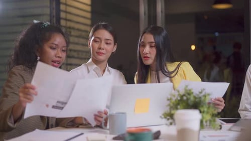 Asian happy business people group have discussion meeting brainstorming on table overtime in office.