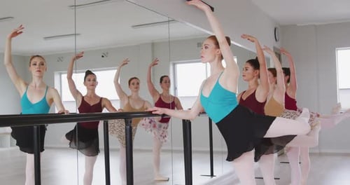 Ballet Dancers Practicing at Barre in Studio