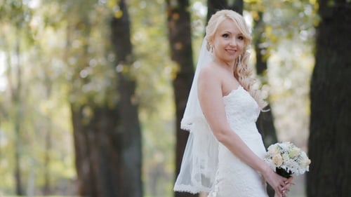 Beautiful Bride Smiling with Bouquet in Park