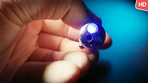 Hand Holding a Glowing Miniature Lamp