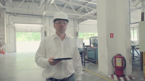 Ingenieur geht durch die Produktionsstätte