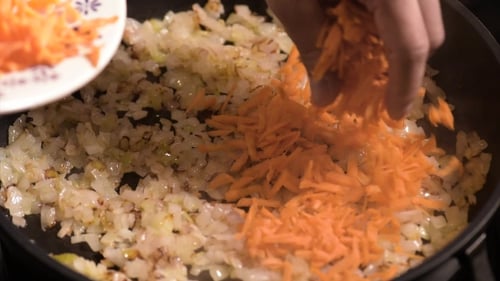 Faire frire les oignons et les carottes sur la poêle