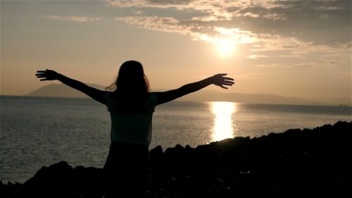 Silhouette Of Wonderful Young Woman Watching To Sea And Raising Her Hands