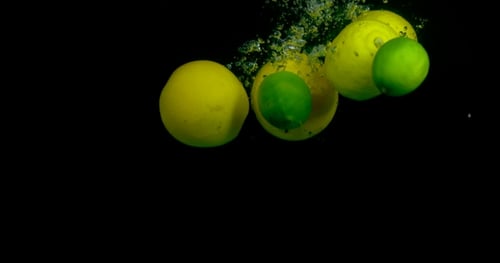 Oranges Falling Into Water In On Black Background