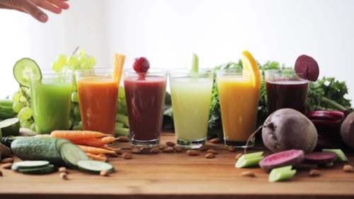 Hand Taking Glass Of Vegetable Juice From Table