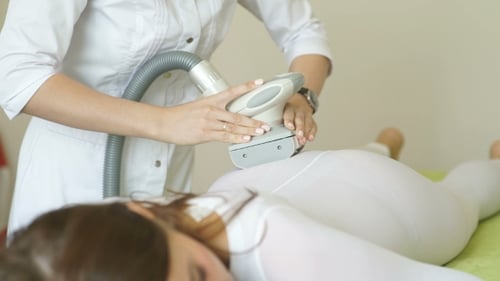 Woman Receives Treatment with Machine on Buttocks