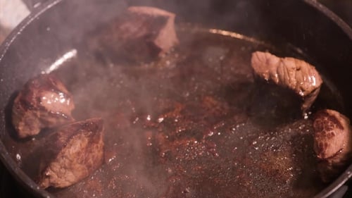 Meat Chunks Sizzle in a Pan While Cooking