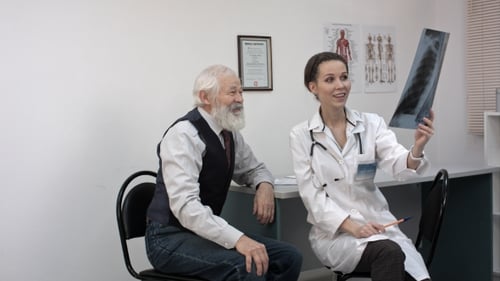 Young Smiling Female Doctor With Stethoscope Looking At X-ray At Doctor's Office.