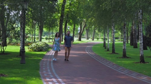 Young Couple Walking Summer Park With Birches.