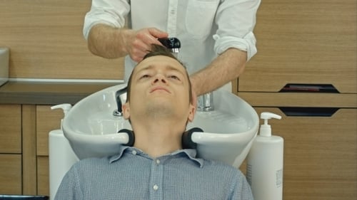 Barber Shampooing Man's Hair in Modern Salon