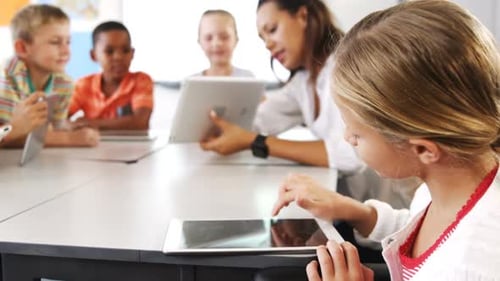 Teacher teaching kid on digital tablet in library