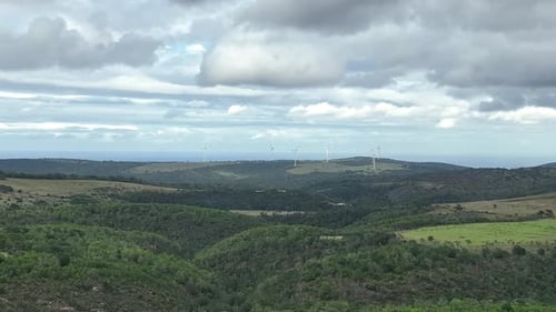 Rolling Hills Landscape with Distant Wind Turbines