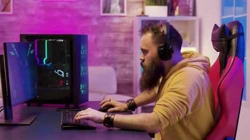 Bearded Man Playing Game at Computer Desk