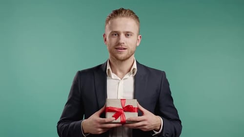 Young Man Holding a Gift Box with Red Ribbon