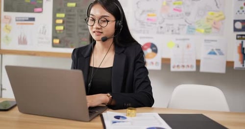 Businesswoman Uses Laptop for Video Conference at Desk