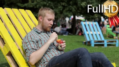Young Adult Enjoying Fruit in a Yellow Deck Chair