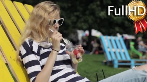 Woman Enjoys Fruit in Park on Sunny Day