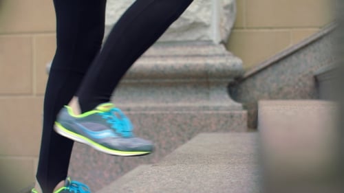 Woman Walking Up Steps in Sneakers and Leggings