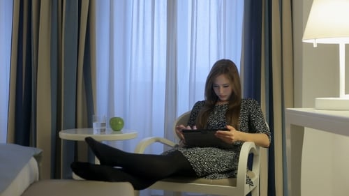Female In Dress Search On Internet By Digital Tablet In Hotel Room
