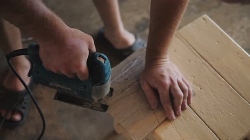 Man Using Jigsaw to Cut Wood