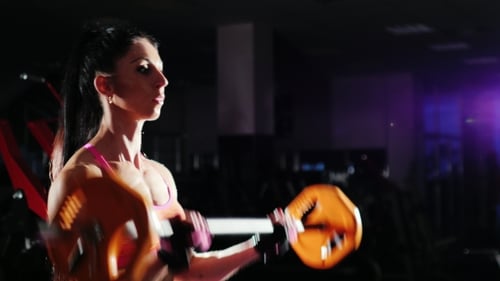 Athletic Woman Lifting Barbell in Gym