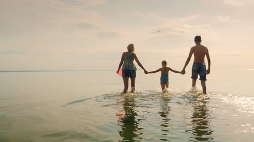 Family Walking into Ocean at Golden Hour
