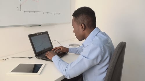 Young Adult Working on Laptop in Office Setting
